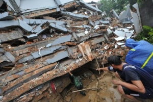 9月30日在印尼蘇門答臘省沿海的巴東地區發生的地震傷亡慘重。圖為10月初救援人員在巴東一家酒店的廢墟下發現了數名生還者，在調動更多人展開營救行動前，救援人員為生還者打氣，要他們挺下去。（圖：印尼星洲日報） <br/>
