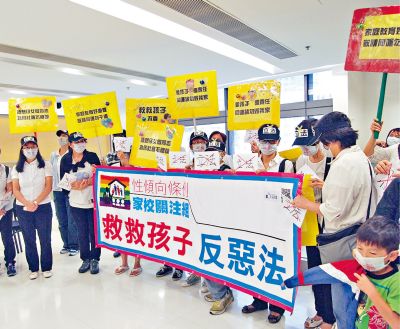 「性傾向條例家校關注組」成員高舉標語，反對性傾向歧視條例立法。（圖：星島日報）