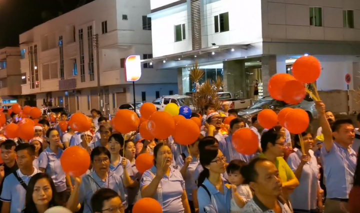 美里市聖誕遊行者手手持紅橙氣球。（圖：Miri Christmas Parade Night 2019）