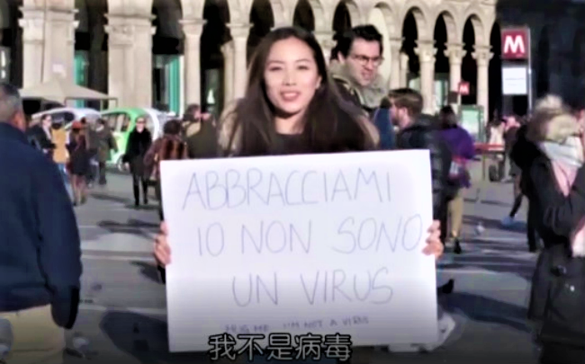 一名中國女子在米蘭市中心廣場手拿「我是中國人，但我不是病毒」大字報 。（圖：義大利微視傳媒）