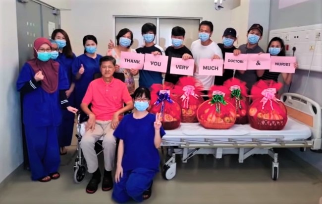 黃靈彪［紅衣坐輪椅］治癒答謝醫護人員。（圖：馬來西亞聖經神學院麾頻擷圖） 