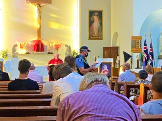  

一名警察中止教堂彌撒，檢查教區居民是否戴口罩。（圖：視頻擷圖） 

 