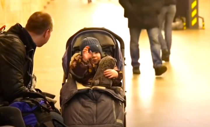 烏克蘭一名嬰兒隨父母躲進地鐵站避炸彈襲擊。（圖：BBC News） 