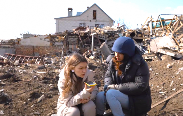 烏克蘭南部尼古拉耶夫市居民Olya［左］稱，為照顧祖父母無法離開被毀的家園，用手機與親友報平安。（圖：VICE News擷圖） 